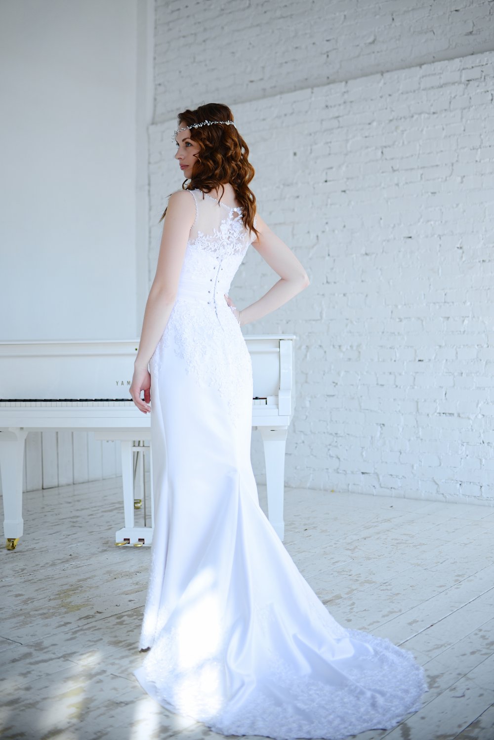 Свадебное платье Аврора из плотного белоснежного атласа, отделанное кружевом и расшитое жемчужинами и кристаллами, с небольшим шлейфом.