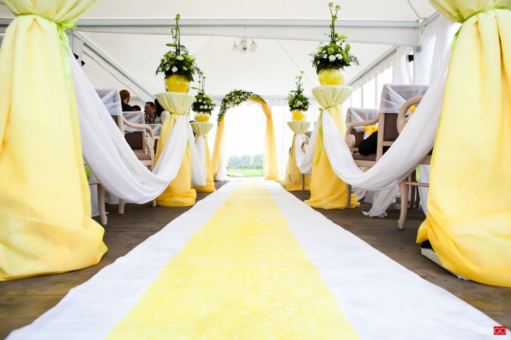 Оформление свадебной церемонии, проходящей в шатре в солнечной гамме 