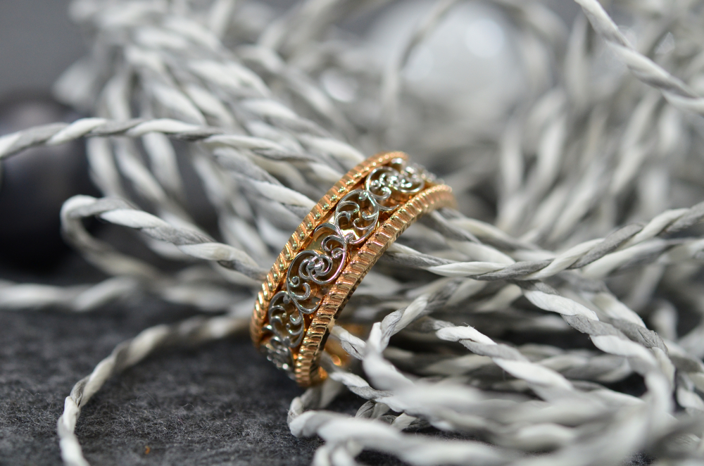 Изящное кольцо из красного и жёлтого золота с растительным узором и плетёной окантовкой