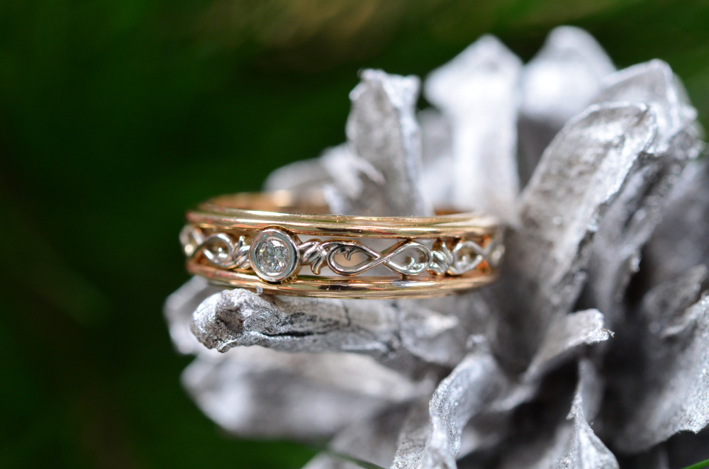 Обручальное кольцо из двух видов золота с символом бесконечности и бриллиантом в глухом закрепе