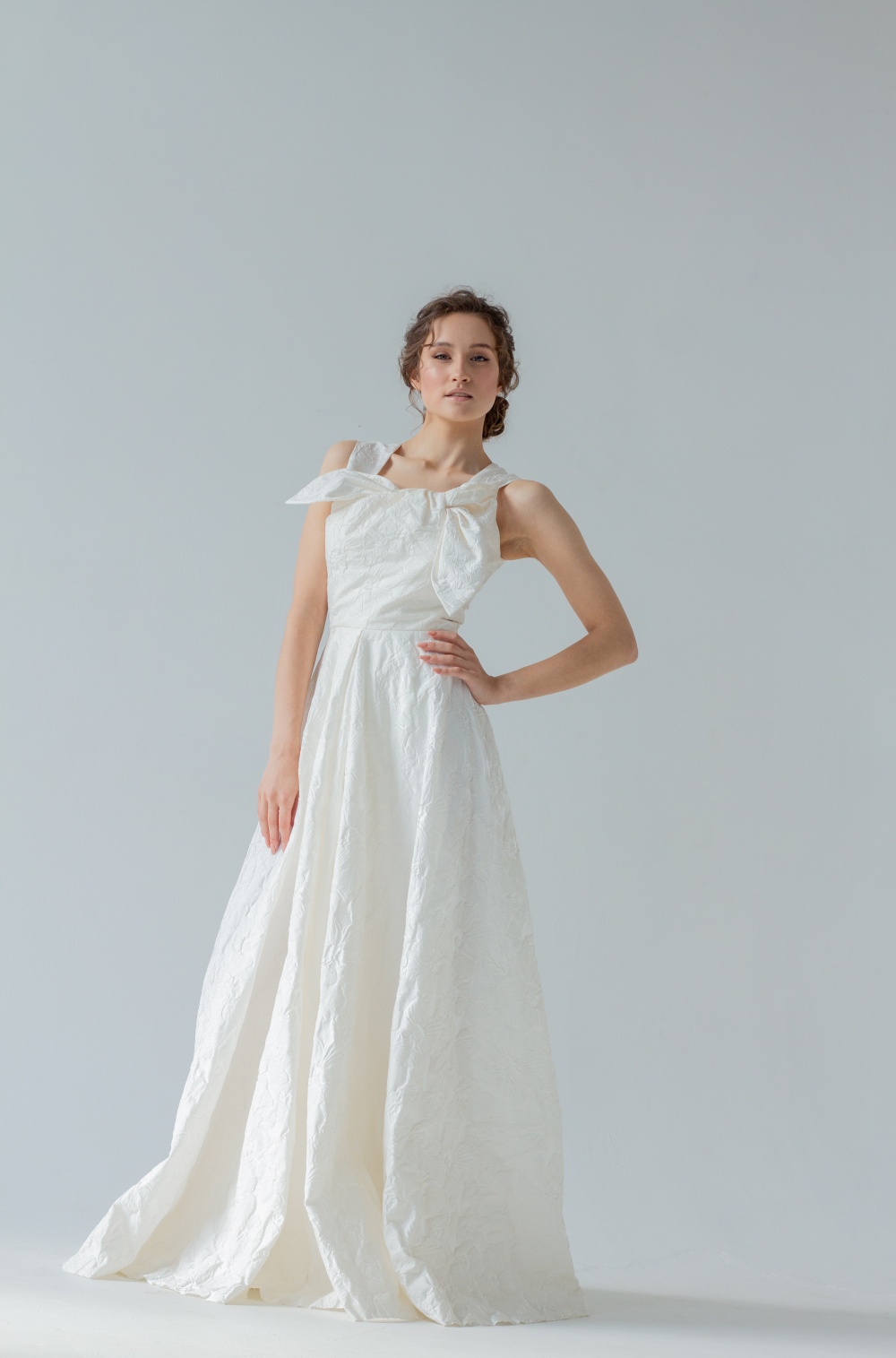 Свадебное платье из мягкой тафты с фактурными цветами, приталенный силуэт украшает бант на груди. Торжественный и лаконичный образ невесты. Размер 42-44.