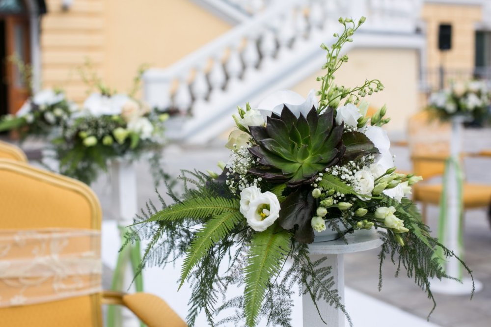 Элементы оформления церемонии флористические композиции на белоснежных столбиках вдоль ковровой дорожки 