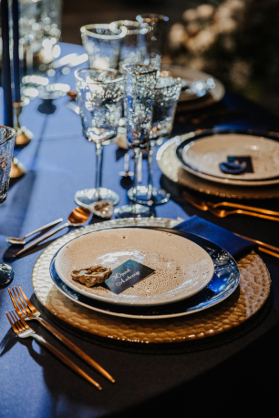 Сервировка космической свадьбы. Тарелки в стилистике луна и космос и каменные детали на рассадке гостей.